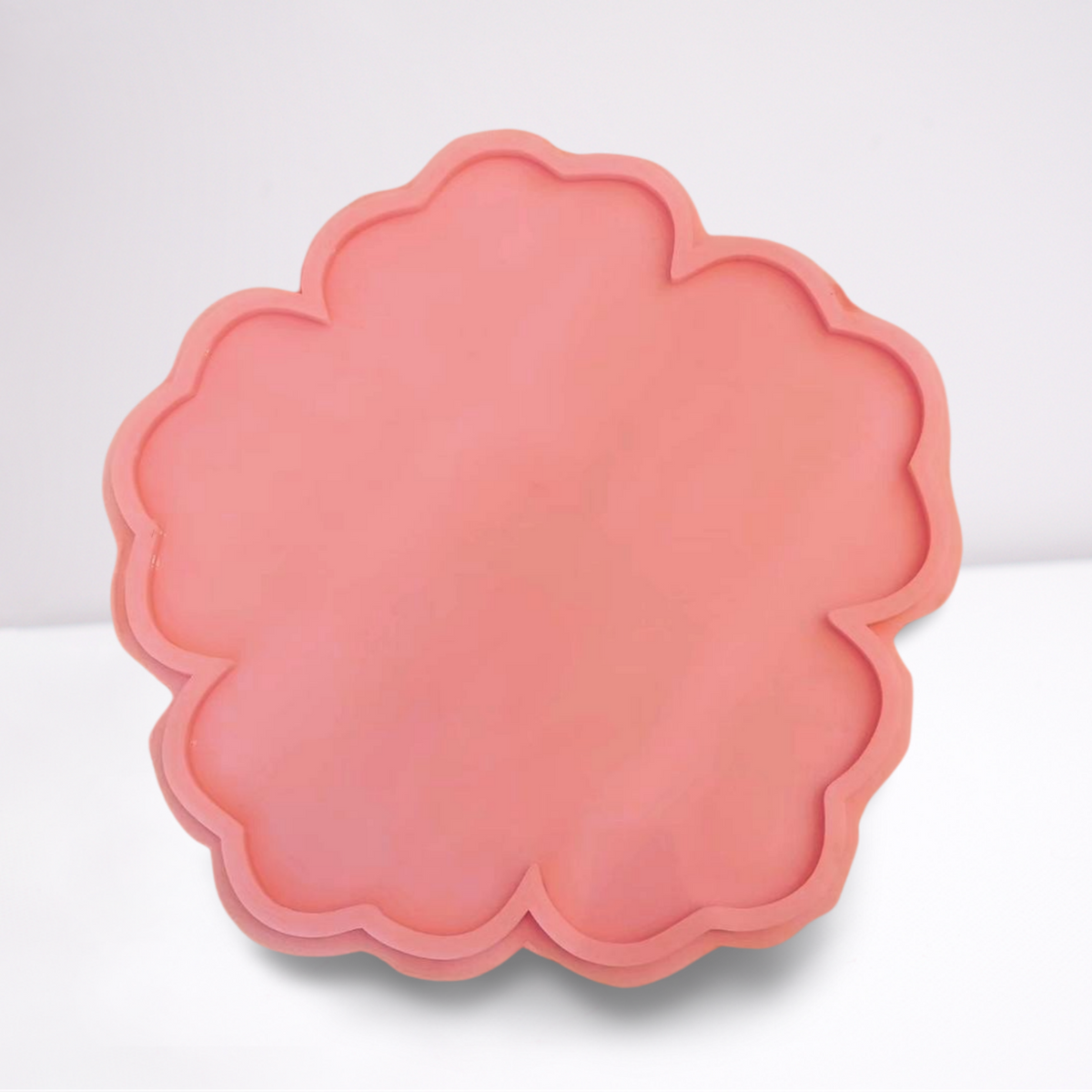 This silicone mold, designed in the shape of a five-petaled flower with regular curved edges, is commonly used to create artistic coasters, small serving trays, or unique home decor pieces.